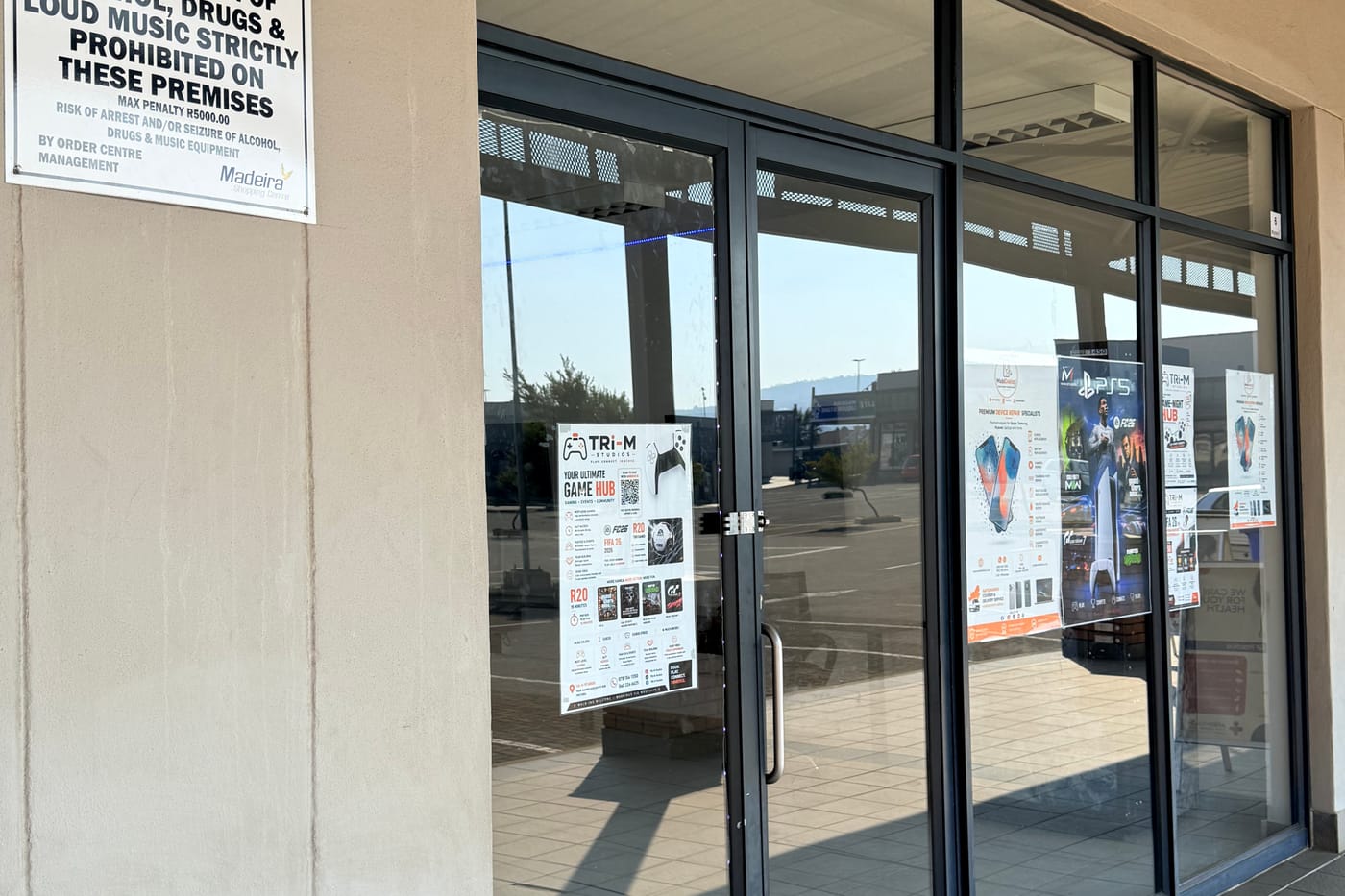 MobiDokta repair and gaming lounge posters in the Shop 6 window at Madeira Isles